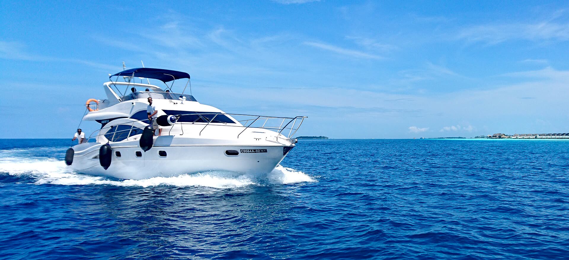 Yate a motor navegando en aguas azul profundo